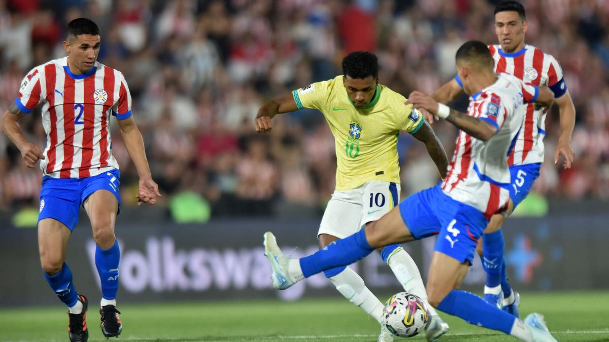 Rodrygo dứt điểm trước sự truy cản của hậu vệ Juan Caceres (số 4). Ảnh: AFP.